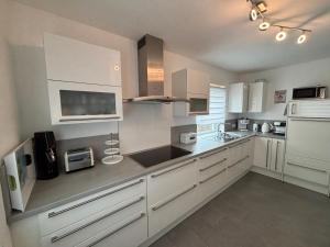 a large white kitchen with white cabinets and appliances at Entspannung am Wald in Wald-Michelbach