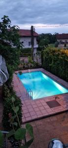 a large blue swimming pool in a yard at Apartman MURKO S-3 in Ig