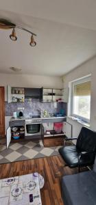 a living room with a kitchen with a couch and a table at Apartman MURKO S-3 in Ig