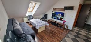 a living room with a couch and a table and a tv at Apartman MURKO S-3 in Ig