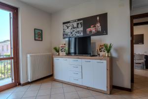 a kitchen with white cabinets and a tv on the wall at Relais Terre Divino 1 in Ponton