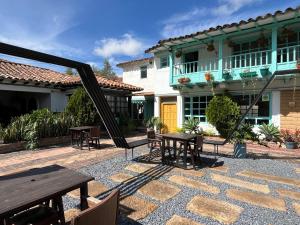 a patio with tables and chairs in front of a house at Hotel Aceitunos in Villa de Leyva