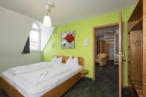 a large bed in a room with a green wall at Hotel Demling in Randersacker