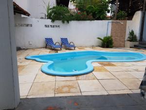 a large blue pool in a patio with two chairs at Casa Dos Vovôs Pousada em Canoa Quebrada in Aracati