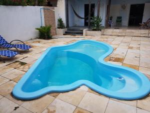 a large blue swimming pool in a yard at Casa Dos Vovôs Pousada em Canoa Quebrada in Aracati