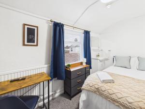 a bedroom with a bed and a desk and a window at Parkview Guest House in King's Lynn
