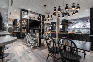 a restaurant with tables and chairs and a bar at HARBR Hotel Ludwigsburg, a member of Radisson Individuals in Ludwigsburg