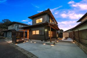 a black house with lights on a driveway at 夢思苑 別府 in Beppu