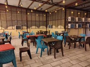 a restaurant with tables and chairs in a room at Hotel Ajmer Pride in Ajmer
