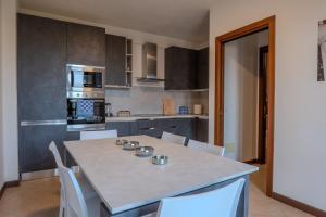 a kitchen with a table and white chairs in it at Relais Terre Divino 1 in Ponton