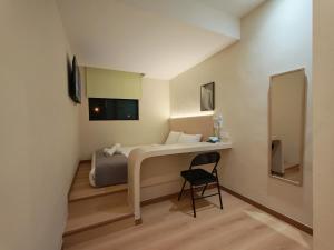 a small room with a bed and a chair at The Loft hotel 68 in Butterworth