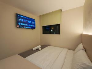 a room with a bed with a tv on the wall at The Loft hotel 68 in Butterworth