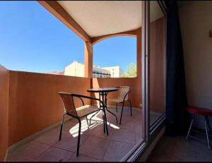a balcony with a table and chairs and a window at Appartement Cap D'Agde in Cap d'Agde