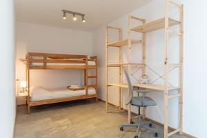 a room with two bunk beds and a desk and a chair at Nest Family, Bedollo Ospitar in Bedollo