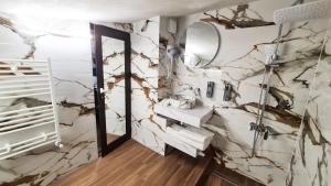 a bathroom with white marble walls and a mirror at Димоли in Elin Pelin +46 photos