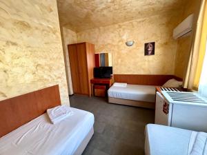 a small room with two beds and a desk at Димоли in Elin Pelin