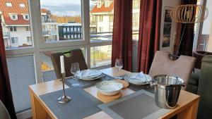 a table with plates and wine glasses and a window at Meerblick 9 - Großenbrode in Grossenbrode