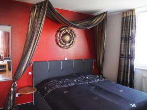a bedroom with a black bed with a red wall at Meerblick 9 - Großenbrode in Grossenbrode
