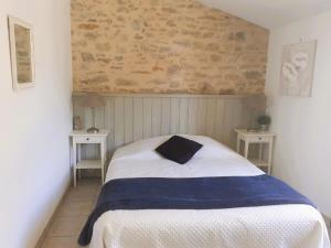 a bedroom with a bed with two tables and a brick wall at Gîtes Arvor et Tevenn in Saint-Brevin-les-Pins