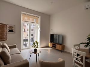 a living room with a couch and a tv at Iberflat San Gregorio in Seville