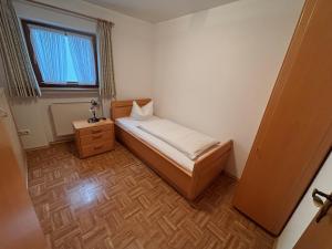 a small bedroom with a bed and a window at Appartementhaus Marion in Bad Bayersoien +5 photos
