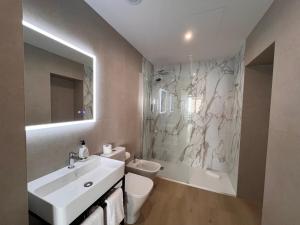 a bathroom with a sink and a toilet and a shower at Iberflat San Gregorio in Seville +63 photos