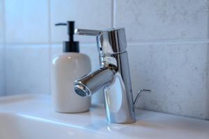 a bathroom sink with a soap dispenser next to a faucet at Relais Terre Divino 1 in Ponton
