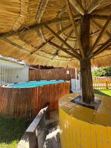 a pavilion with a bench under a straw umbrella at A queridinha do Orange in Itamaracá