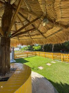 a large wooden pavilion with a tree in a yard at A queridinha do Orange in Itamaracá