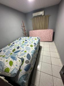 a bedroom with a bed with a comforter at A queridinha do Orange in Itamaracá +14 photos