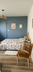 a bedroom with a bed and a table with a chair at Studio85 in La Gaubretière