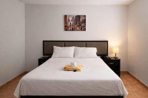 a bedroom with a bed with a towel on it at Hotel Kuwasi in Chiclayo