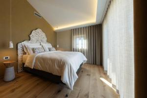 a bedroom with a large bed and a window at Josefina unique hotel, adult only in Kozina