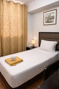 a bedroom with a bed with a towel on it at Hotel Kuwasi in Chiclayo