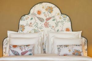a bed with a floral headboard and pillows at Josefina unique hotel, adult only in Kozina