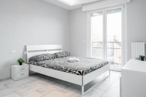 a white bedroom with a bed and a window at Victory76 - Hospital, M3, Linate in San Donato Milanese