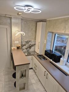 a kitchen with white cabinets and a counter top at Edward Luxury Studio in Slănic-Moldova