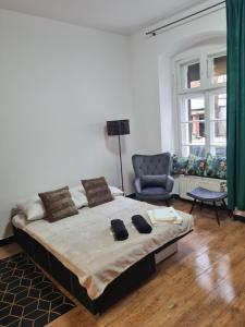 a bedroom with a large bed and a chair at Zakątek Spokoju in Toruń