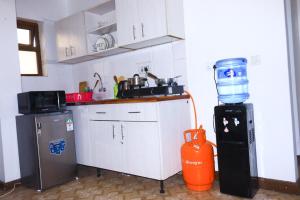 a kitchen with an orange water cooler and a refrigerator at Emeli apartments in Nairobi