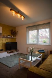 a living room with a coffee table and a tv at Kuća za odmor Kiljer - priroda, pogled i slavonski ugođaj in Grgurevići