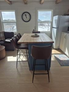 eine Küche mit einer Kücheninsel und einer Wanduhr. in der Unterkunft Durrell's Nook in Twillingate
