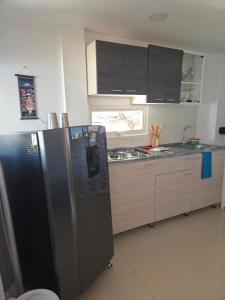 a kitchen with a stainless steel refrigerator and a sink at Cabañas Annapurna - Cabaña #12 in Taganga