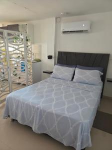 a bedroom with a bed with a white comforter at Cabañas Annapurna - Cabaña #12 in Taganga