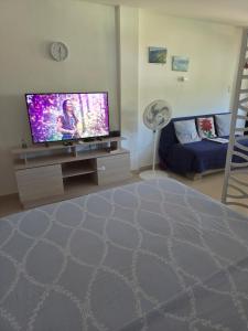 a living room with a flat screen tv and a bed at Cabañas Annapurna - Cabaña #12 in Taganga