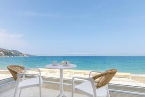 a table and chairs with a view of the ocean at Azzure Studio in Kokkari