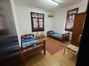 a room with two beds and a door and two windows at PRIBO's in Flic-en-Flac
