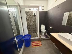 a bathroom with a shower and a toilet and a sink at PRIBO's in Flic-en-Flac +47 photos