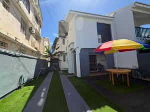 a patio with a table and an umbrella at PRIBO's in Flic-en-Flac