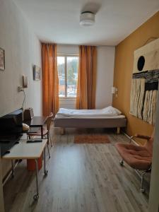 a bedroom with a bed and a desk and a window at Dorotea Logi B&B in Dorotea
