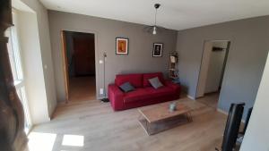 a living room with a red couch and a coffee table at Maison de campagne in La Fouillade